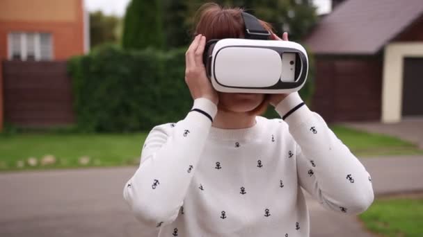 Jonge roodharige vrouw met behulp van Vr-helm voor slimme telefoons. Augmented reality — Stockvideo