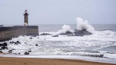 Okyanustaki bir fenerin yanında fırtına dalgaları