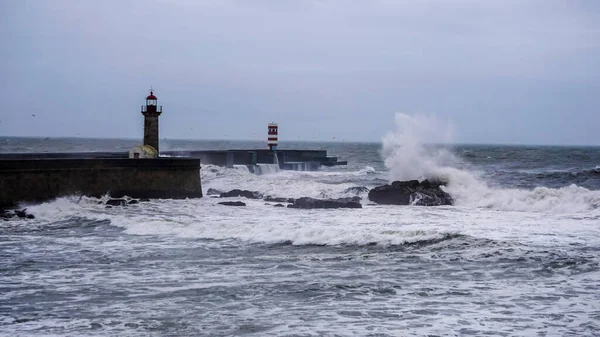 Storm waves next to a lighthouse on the ocean