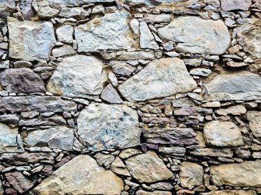 Taşlardan bir duvar, kırsal ve ortaçağ tarzı. Duvar kağıdı, taş arkaplan.