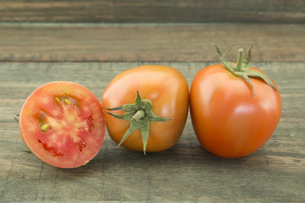 Smakelijke rode tomaten op houten achtergrond. — Stockfoto