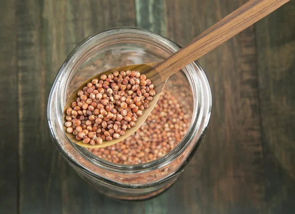 Sorgo in vaso di vetro su fondo di legno — Foto Stock