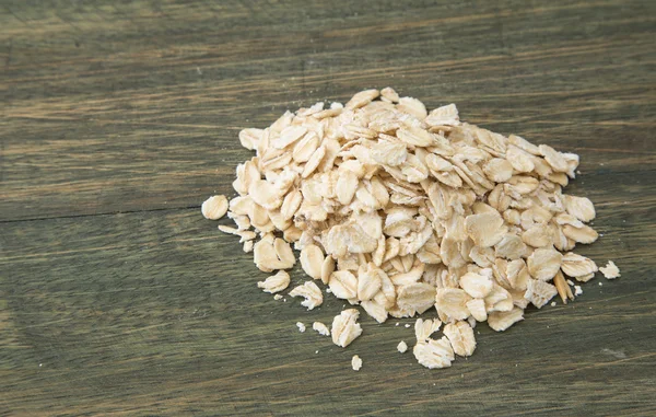 Oat flakes pile on wooden background