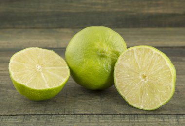 ahşap masa üzerinde yeşil limon