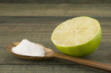 kabartma tozu (sodyum bikarbonat) bir tahta kaşık ve limon