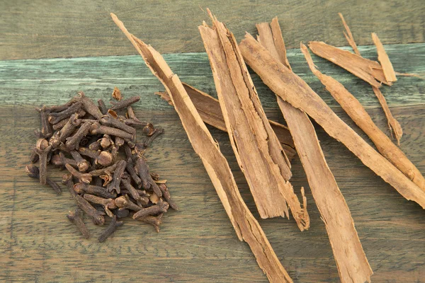 Canela e cravo na mesa de madeira — Fotografia de Stock