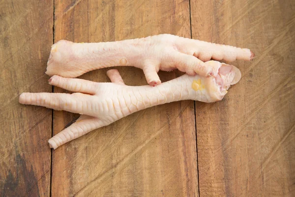 Курячі ноги на дерев'яному фоні — стокове фото