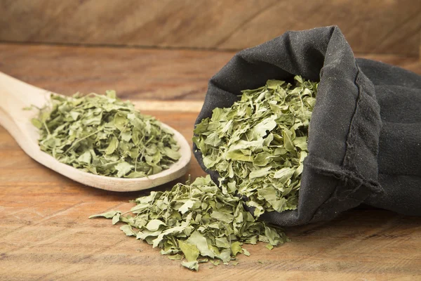 Hojas de Moringa sobre fondo de madera — Foto de Stock