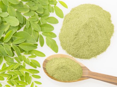 Moringa yaprakları ve beyaz arka plan üzerinde tozu