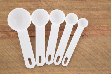 Plastik kaşık ahşap arka plan üzerinde ölçüm