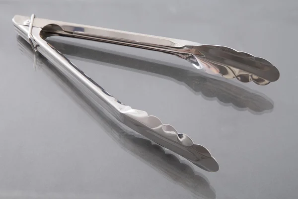 Serving kitchen tongs isolated on a neutral background — Stock Photo, Image