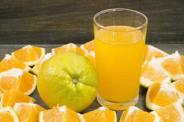 Rodajas de naranja y vaso de jugo . — Foto de Stock