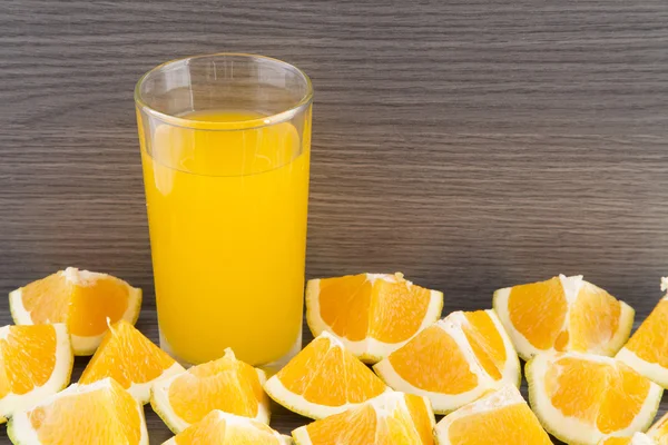 Slices of orange and glass of juice.