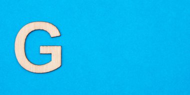 Mavi arka planda tahtada G harfi.