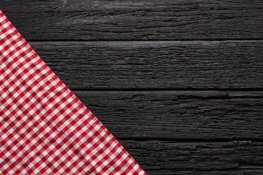 Checkered napkin on a dark rustic background, with space for text