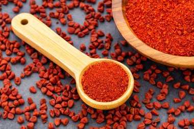 Kaşıkta ve kasede ezilmiş annatto tohumları - Bixa Orellana