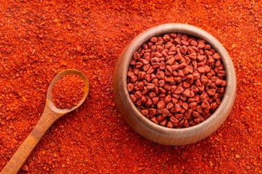 Kaşıkta ve kasede ezilmiş annatto tohumları - Bixa Orellana