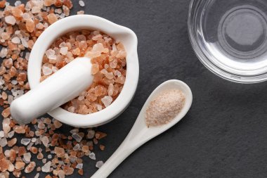 Himalaya pembe tuz kristalleri havanda, kasede ve kaşıkta. Suyla karıştır