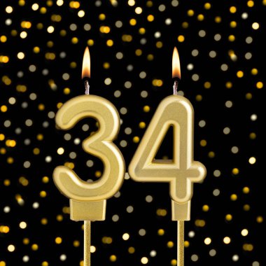 Siyah arkaplanda bulanık ışıklarla 34 numaralı doğum günü mumu.