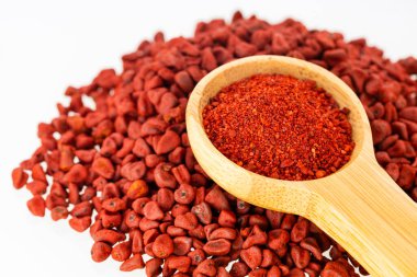 Organik kırmızı notatto tozu ve ölçü kaşığındaki tohumlar - Bixa Orellana