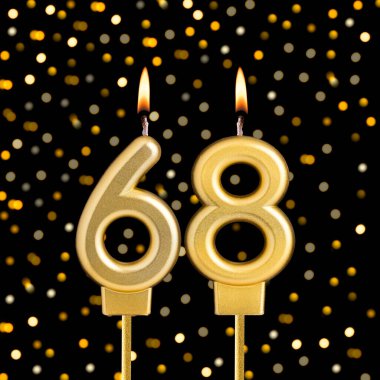 Siyah arka planda, bulanık ışıkları olan 68 numaralı doğum günü mumu.