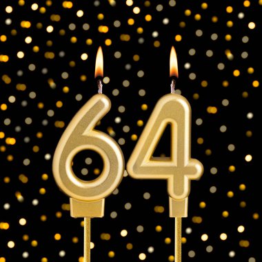 64 numaralı doğum günü mumu bulanık ışıklarla siyah bir arkaplanda.