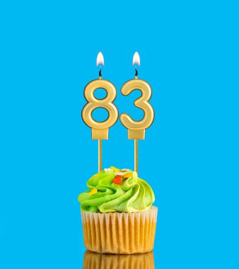 83 numaralı mum - Mavi arkaplanda kek olan doğum günü kartı