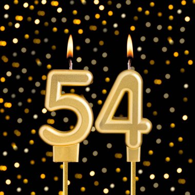 Bulanık ışıklarla siyah arkaplanda 54 numara doğum günü mumu.