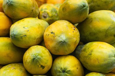 Yerel bir Kolombiya pazarında, geleneksel ticaret, tarım ve sağlıklı beslenmeyi yansıtan taze papaya resmi..