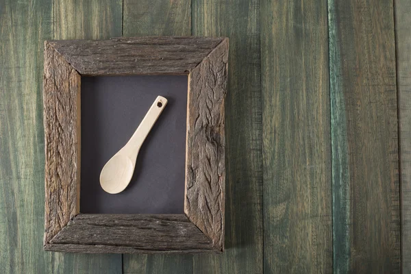 Blackboard on wooden surface and serving spoons — Stock Photo, Image