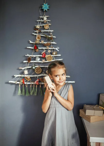 Happy Girl Gospodarstwa Obecnie Pudełko Pobliżu Oryginalnej Alternatywnej Choinki Wykonane — Zdjęcie stockowe