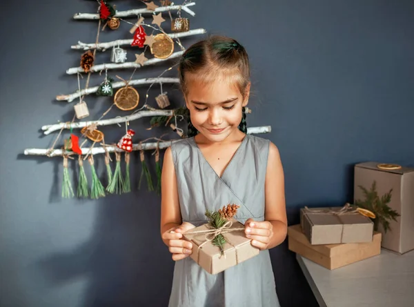 Happy Girl Holding Out Present Box Original Alternative Christmas Tree — Stock Photo, Image