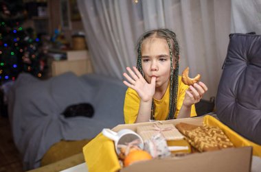 Şirin kız, büyükannen için çay, bal, kurabiye ve yün çorap paketliyor. Kilitleme sırasında kişisel bakım kutusu, Noel 'de aile ve dostlara destek ve sürpriz