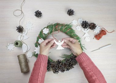 Noel arifesi için köknar çelengi yapan bir kadın ve onu yıldızlarla süslemek ve ev yapımı tuzlu hamur, diy zanaat dekorasyonu, kış gelenekleri, mevsimsel tatiller ile melekler. Üst görünüm