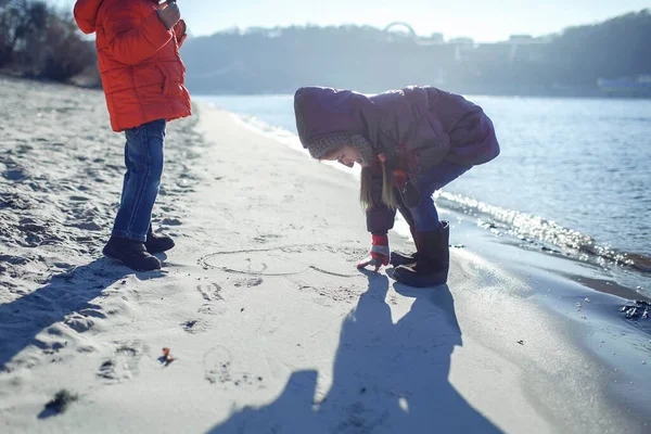 Familia disfrutando del invierno juntos, niños caminando en la playa en invierno, estilo de vida al aire libre — Foto de Stock