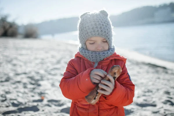 Dziecko spacerujące zimą po plaży, zimna temperatura i słoneczny dzień, miłość cię ogrzewa — Zdjęcie stockowe