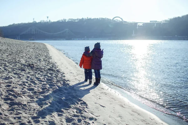 Семья, наслаждающаяся зимой вместе, дети, гуляющие на пляже зимой, уличный образ жизни — стоковое фото