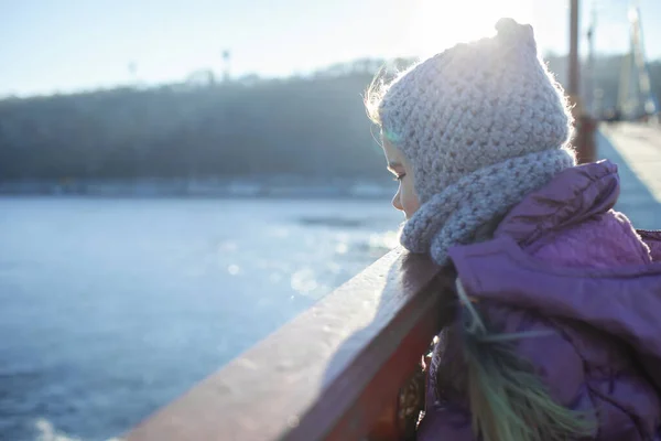 Dziecko przechodzące zimą przez most dla pieszych, zimna temperatura i słoneczny dzień — Zdjęcie stockowe