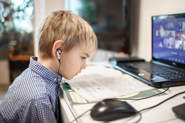 Дистанционное образование, онлайн-занятия. Дошкольный мальчик учится на домашнем уроке онлайн — стоковое фото