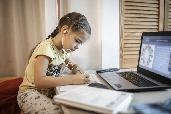 Дистанционное образование, онлайн-занятия. Девушка в пижамных брюках учится на уроке онлайн дома — стоковое фото