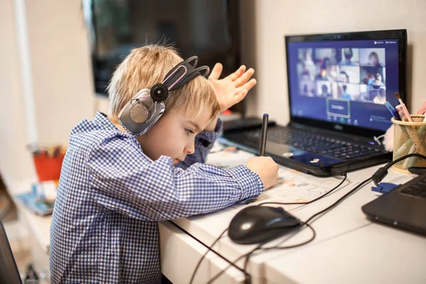 Afstandsonderwijs, online klassenvergadering. Kleuterjongen die thuis tijdens online les studeert — Stockfoto