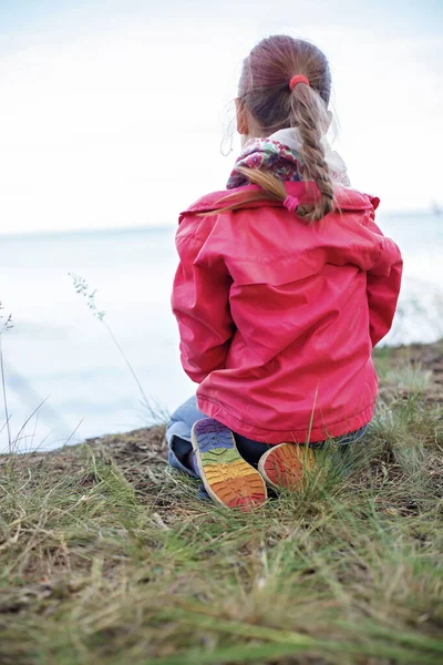 Bella ragazza in scarpe con fondo color arcobaleno seduta sulla riva del mare, ragazze potenza e tolleranza — Foto Stock