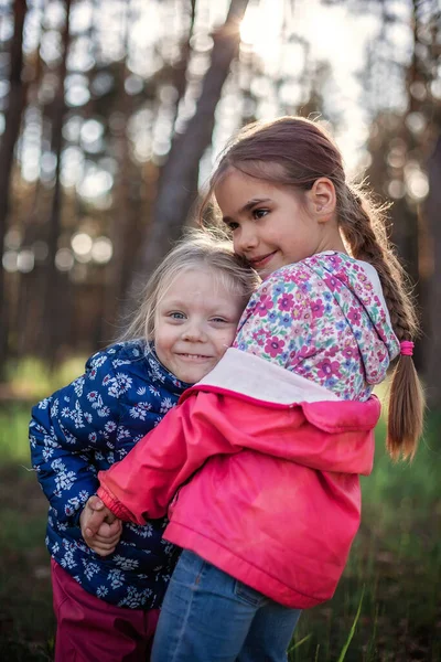 Linda Chica Abrazando Hermana Pequeña Con Amor Ternura Durante Caminar — Foto de Stock