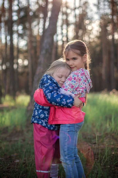 Linda Chica Abrazando Hermana Pequeña Con Amor Ternura Durante Caminar — Foto de Stock