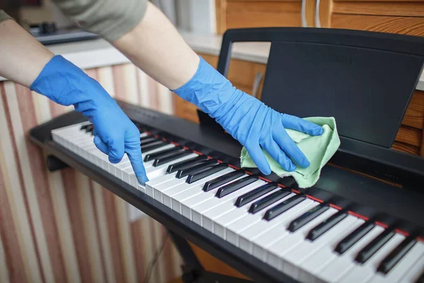 Genç bir kadın evi temizliyor, dijital piyanonun tozunu siliyor ve müzik hayali kuruyor, her anın tadını çıkarıyor. Ev işi. Ev işleri ve iç hayat konsepti. Otantik, kapalı bir yaşam tarzı.
