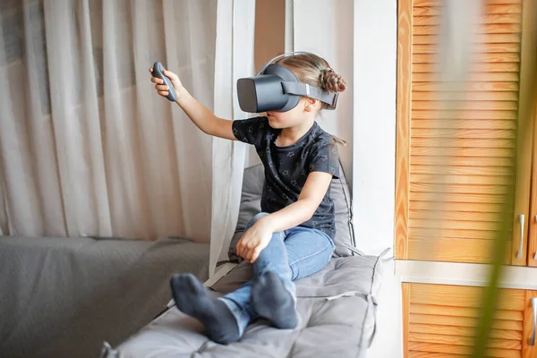 Cute girl in virtual reality googles at home, remote education experiment, future today