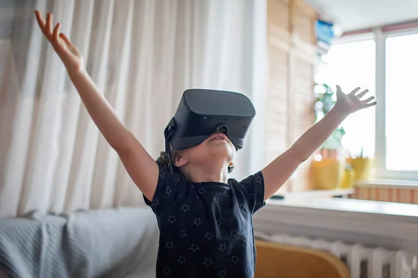 Cute girl in virtual reality googles at home, remote education experiment, future today