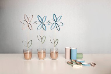 Anneler Günü için tuvalet kağıdı tüpünden çiçekler, çocuklar için sıfır atık aracı, tarafsız pastel arka plan.