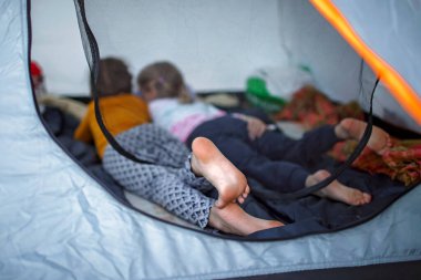 Aile kaçamağı. Çocuk kamp alanındaki çadırda dinleniyor, aktif bir yaşam tarzı var.