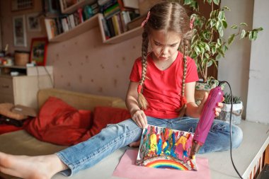 Kız gökkuşağını eritilmiş kalemlerle çiziyor, saç kurutma makinesi ve balmumu yıldızlarıyla eritiyor, sanat fikri.